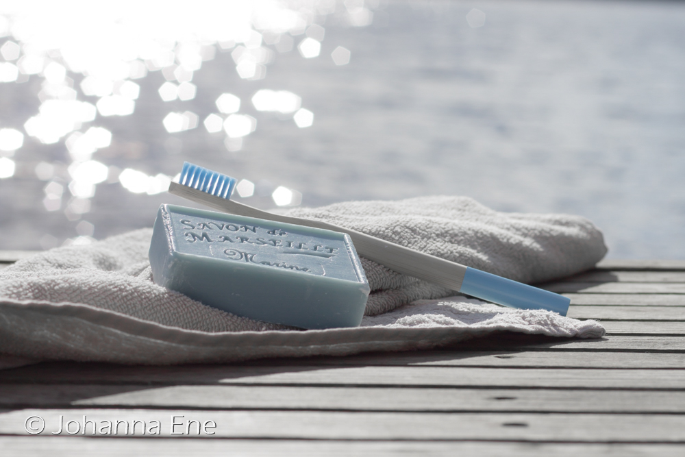 Semestertider. Glöm inte tandborsten. Tandborste i bambu på en brygga med en handduk och tvål. Foto Johanna Ene.